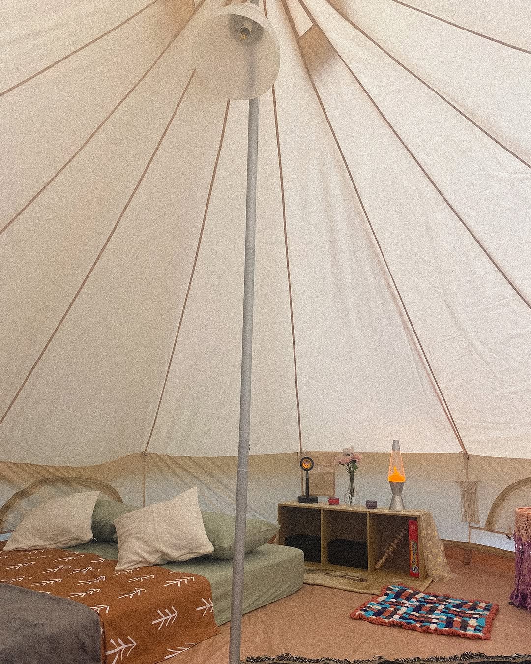 Interior of bell tent with canvas ceiling and boho furnishings