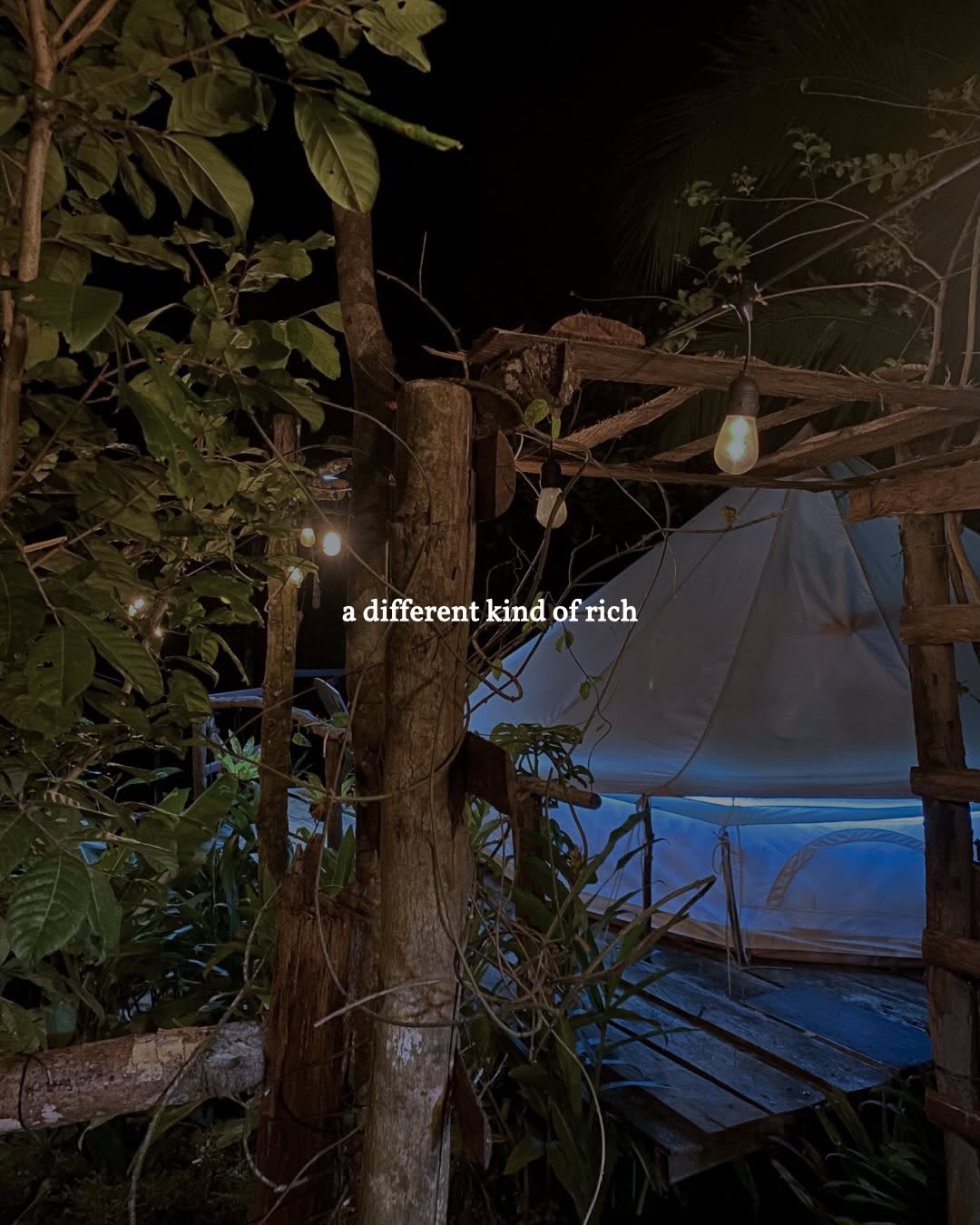 Bell tent at night with string lights in the jungle at Sapa de la Belle